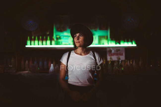 Mujer confiada posando en el bar y mirando hacia otro lado - foto de stock