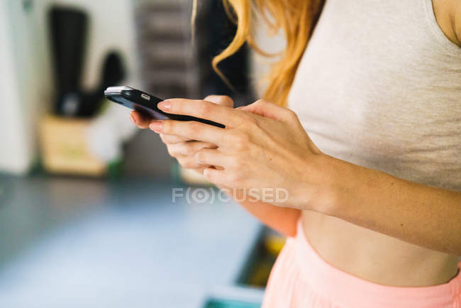 Обрізати жінку за допомогою смартфона вдома — стокове фото