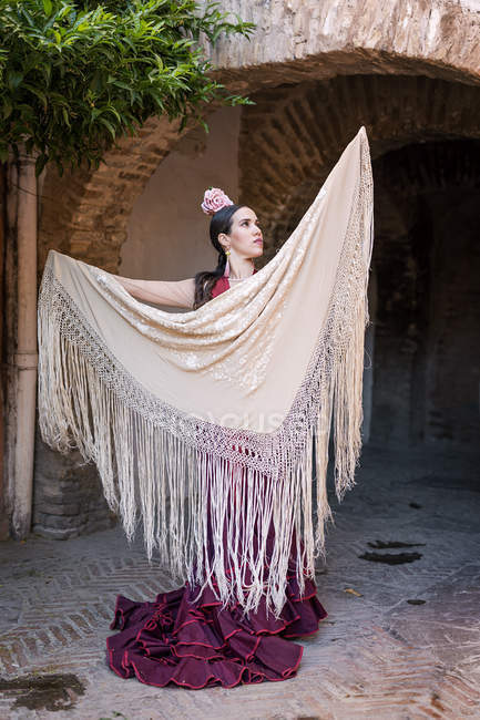 Portrait of flamenco dancer posing with shawl at archway — Stock Photo