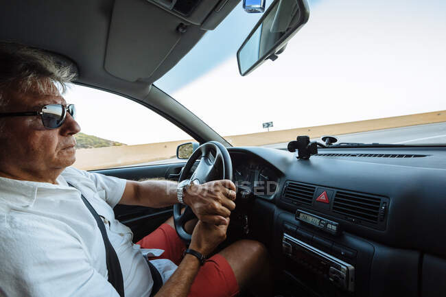 Hombre conduciendo al atardecer - foto de stock