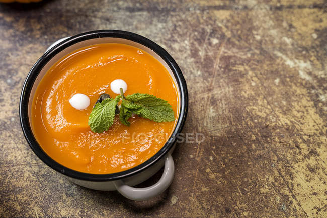Low angle view of homemade cream of pumpkin with mint leaves in sauce pot — Stock Photo