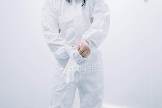 Crop scientist putting on gloves at laboratory — Stock Photo