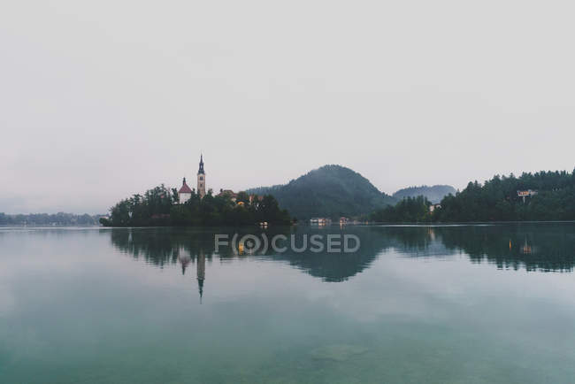 Paesaggio del lago con edifici a torre sulla riva opposta — Foto stock