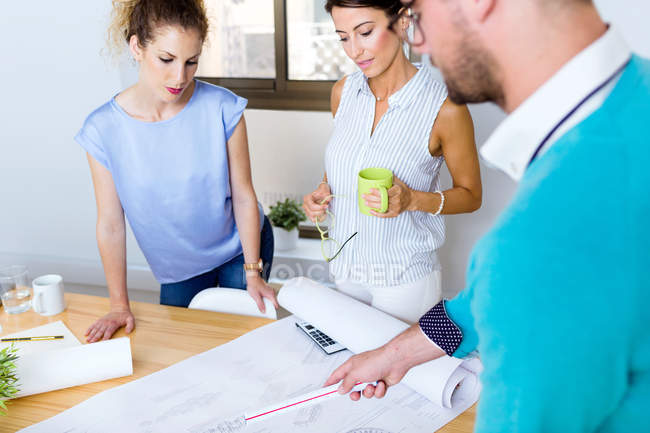 Portrait of business people at table in modern office discussing project plan — Stock Photo