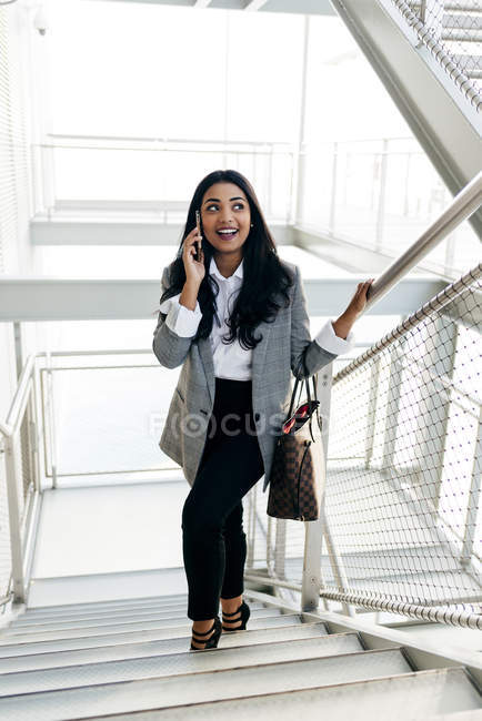 Donna d'affari avendo conversazione telefonica sul passaggio scale — Foto stock