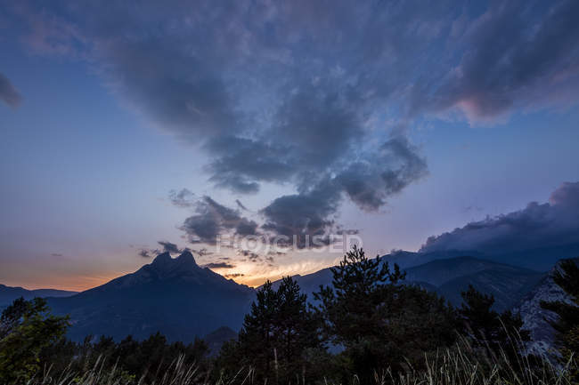 Panorama panorâmico do pôr do sol céu e montanhas cume — Fotografia de Stock