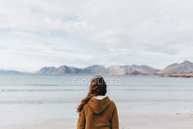 Жінка позаду позує на гірському озері — стокове фото