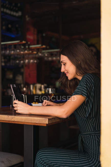 Side view of woman sitting at laptop in cafe — Stock Photo