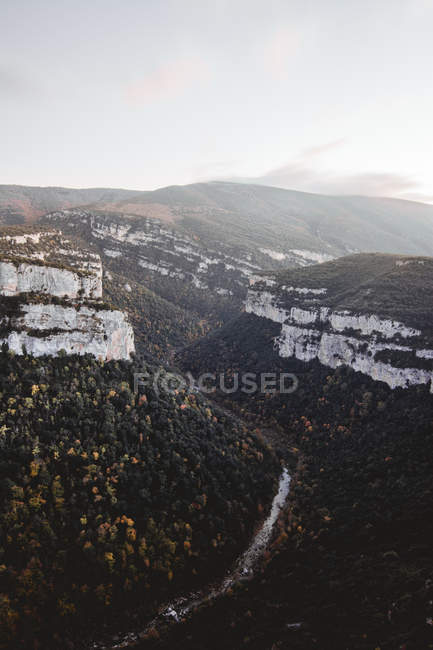 Живописный вид на белые скалы и узкую реку, текущую по лугу — стоковое фото