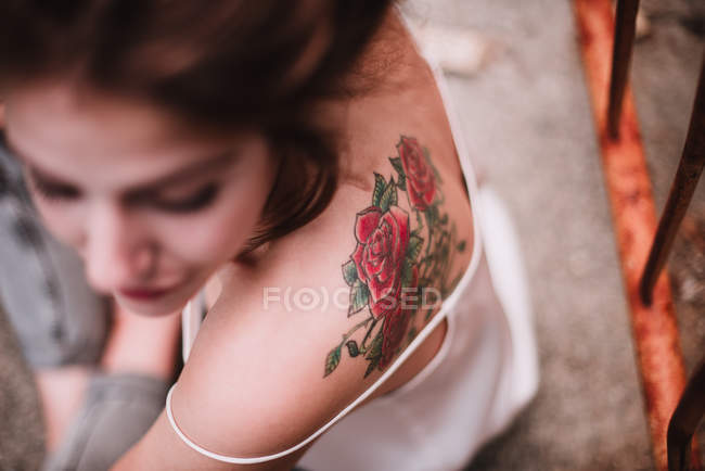Vista de ángulo bajo de la mujer con la espalda tatuada - foto de stock