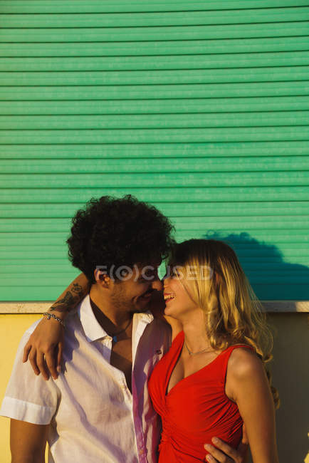 Loving passionate couple embracing beside coastal building facade — Stock Photo