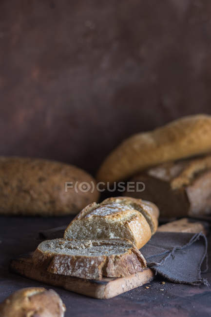 Home-made bread slices on rustic board — Stock Photo