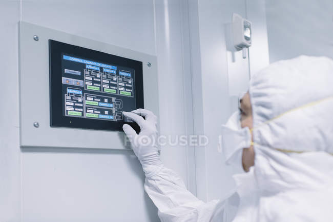 Vista lateral do cientista fornecendo pesquisa e operando com tablet na parede do laboratório . — Fotografia de Stock