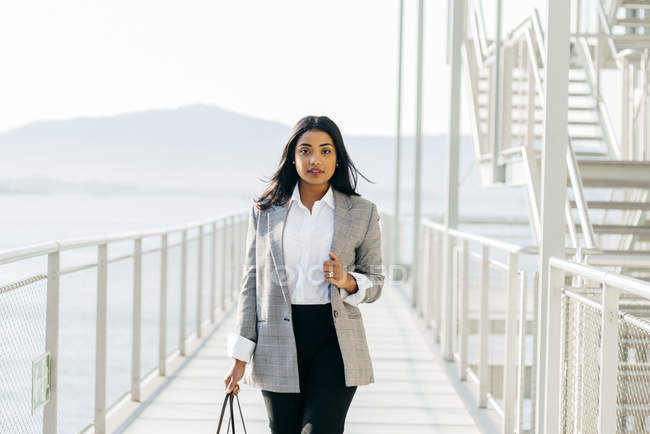 Portrait of businesswoman in jacket posing at balcony passage — Stock Photo
