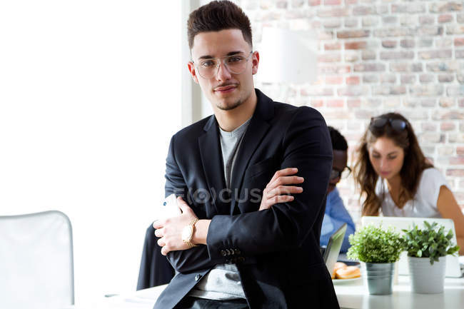 Portrait of young businessman looking at camera at modern office — Stock Photo