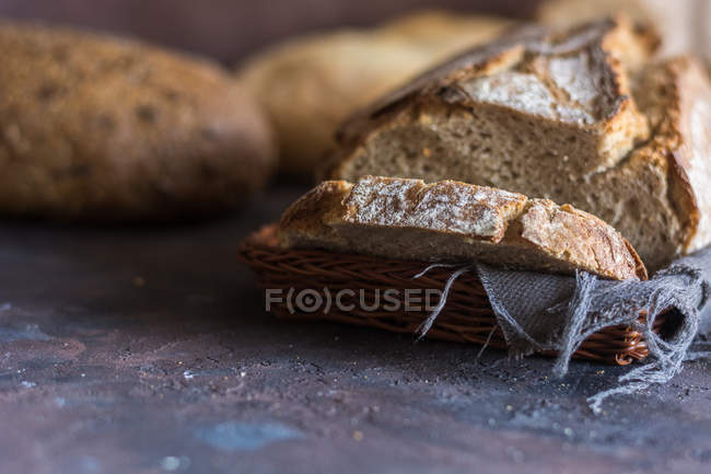 Close up view of fresh home-made bread slices in straw basket — Stock Photo