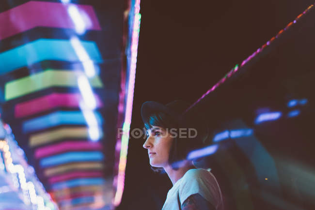 Вид збоку на стомлену жінку, позуючи в освітленому нічному парку — стокове фото