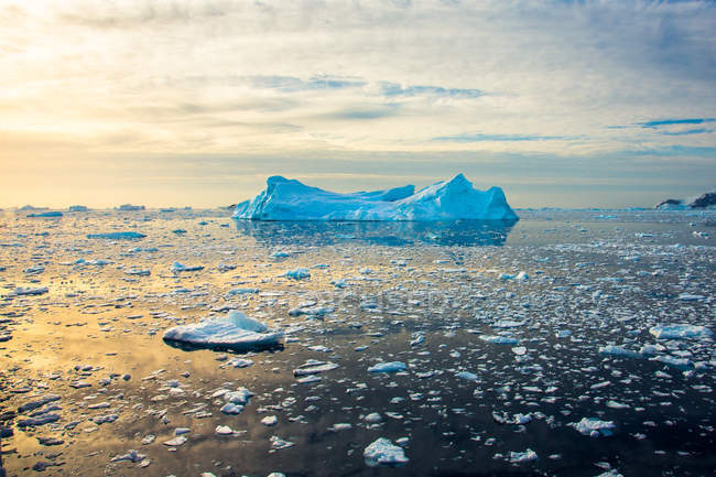 Vista panorámica de carámbanos e iceberg flotando en la bahía sobre el cielo del atardecer - foto de stock