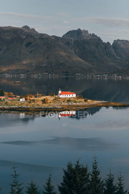 Vista a distanza degli edifici rurali situati sull'isola del lago di montagna — Foto stock