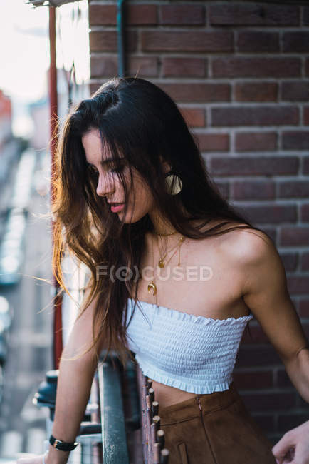 Portrait of brunette girl in top looking down from balcony — Stock Photo