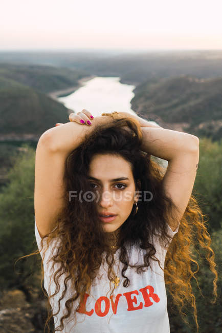 Bruna donna in posa con le braccia alzate sopra paesaggio valle di montagna — Foto stock
