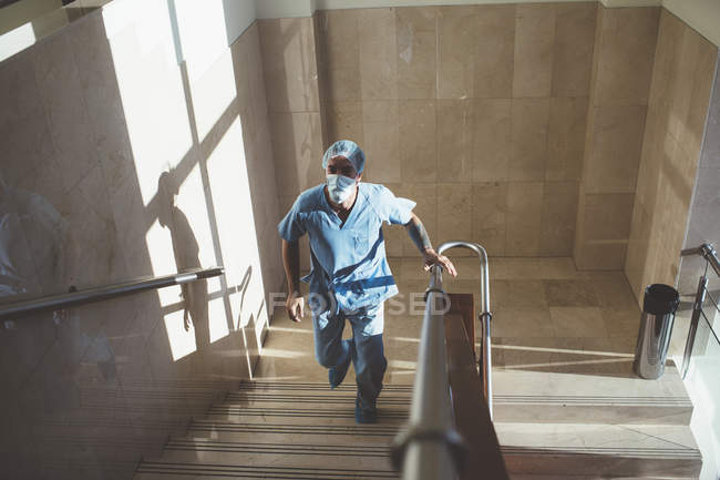 Mann in Arztuniform läuft Treppe im Krankenhaus hinauf — Stockfoto