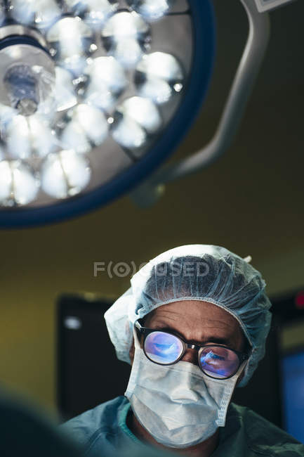 Portrait of thoughtful surgeon looking down at operating room — Stock Photo
