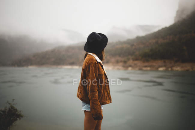 Rückansicht einer Frau mit Hut beim Blick auf die herbstliche Landschaft — Stockfoto