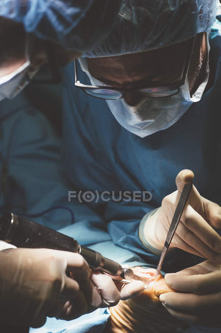 Chirurgiens concentrés en uniforme opérant patient avec des instruments spéciaux . — Photo de stock