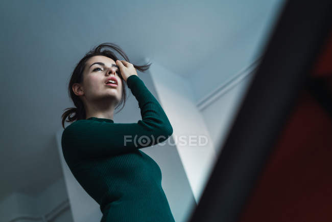 High angle view of brunette in green dress adjusting hair — Stock Photo