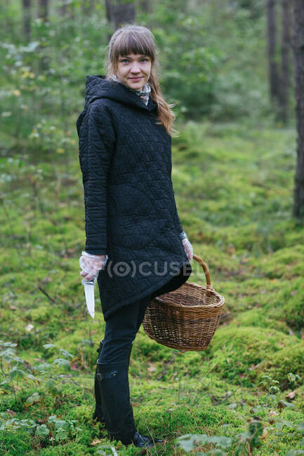 Woman collecting mushrooms in woods — Stock Photo