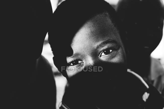Goree, Senegal- December 6, 2017: Close up view of thoughtful African little boy in shadow looking at camera. — Stock Photo