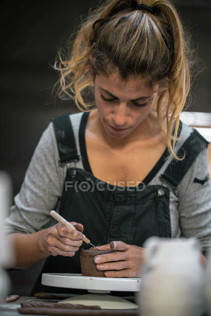 Портрет концентрированной женщины-гончара, работающей с глиной — стоковое фото