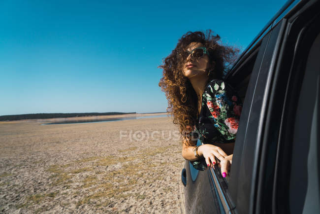 Жінка дивиться верхи на машину в пустелі — стокове фото