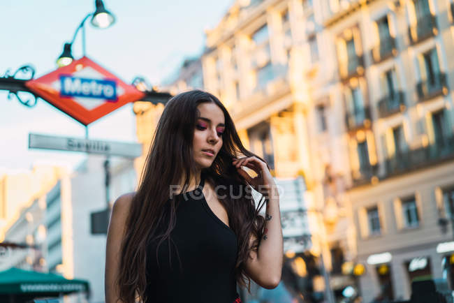 Ritratto di bruna che cammina per strada e agita i capelli — Foto stock