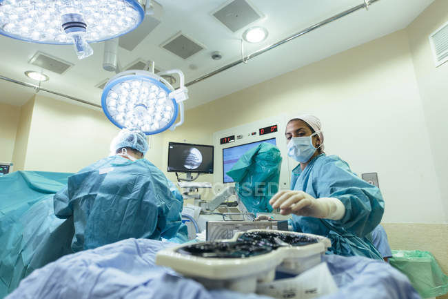 Grupo de médicos que trabajan en la sala de cirugía del hospital - foto de stock