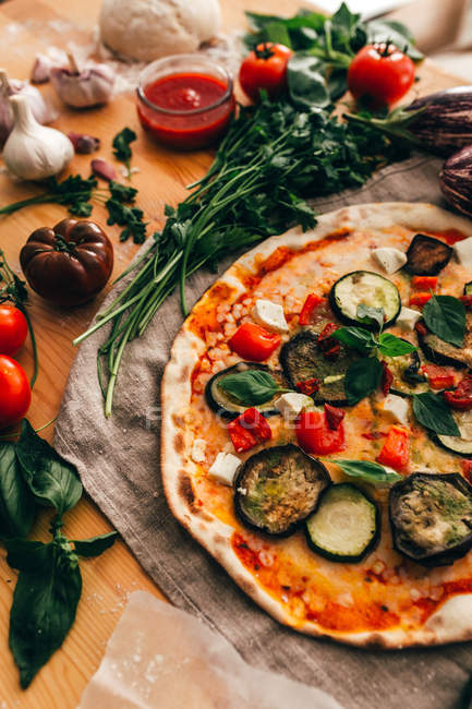 Повнокадровий знімок піци та інгредієнтів на столі — стокове фото