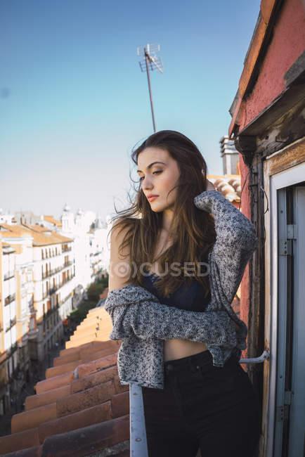 Чуттєва брюнетка дівчина обіймається на балконі — стокове фото