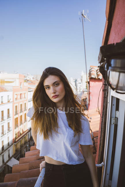 Fiduciosa ragazza bruna in posa sul balcone e guardando la fotocamera — Foto stock