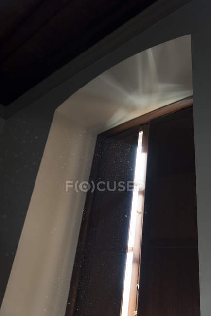 Low angle view of dust specks through window in sunlight — Stock Photo