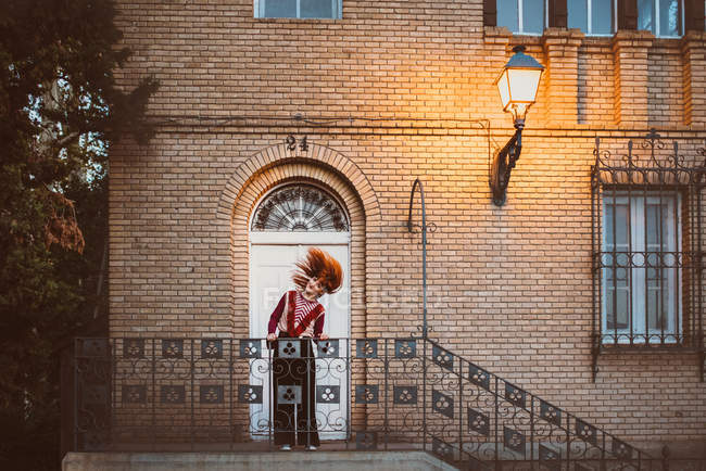 Woman waving hair on doorway stairs — Stock Photo