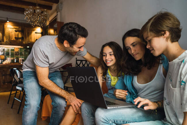 Contenuto famiglia che guarda laptop a casa — Foto stock