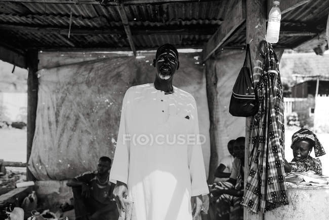 Goree, Senegal- 6 de dezembro de 2017: Retrato de pessoas passando tempo na sombra na rua no bairro pobre . — Fotografia de Stock