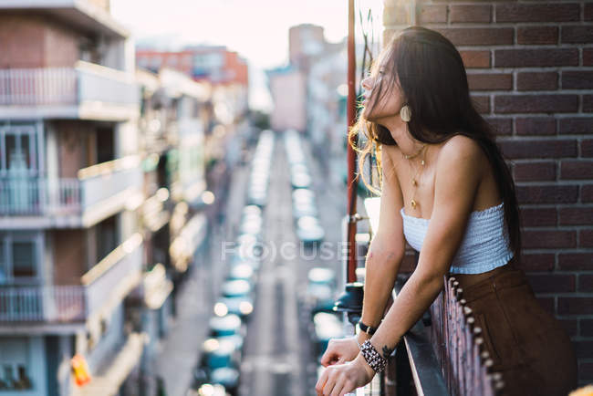 Vista lateral da menina morena posando romanticamente na varanda — Fotografia de Stock