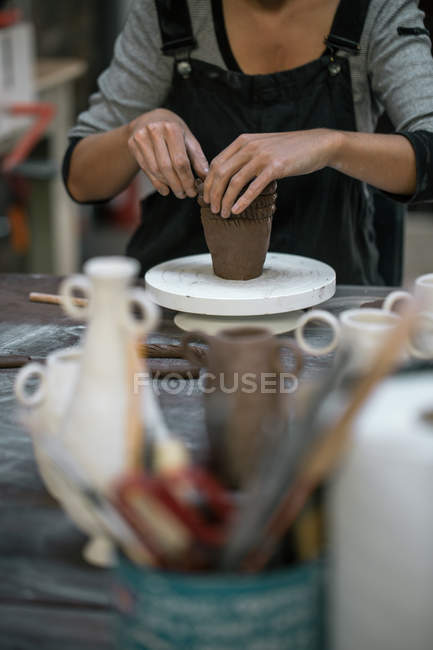 Mid section of woman forming pot from clay — Stock Photo