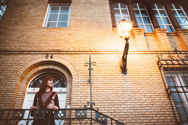 Hochwinkelaufnahme einer rothaarigen Frau, die auf einer Treppe posiert — Stockfoto