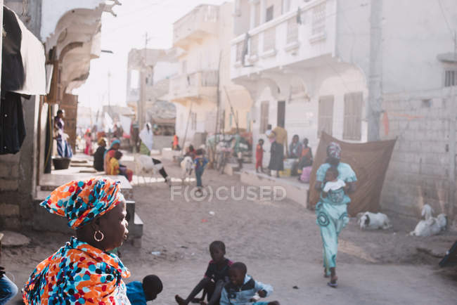 Goree, senegal- 6. Dezember 2017: Menschen gehen an einem sonnigen Tag durch die Straßen einer kleinen afrikanischen Stadt. — Stockfoto