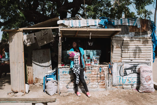 Goree, Senegal- Dezembro 6, 2017: Mulher africana em roupas casuais de pé perto da barraca de rua no dia ensolarado . — Fotografia de Stock