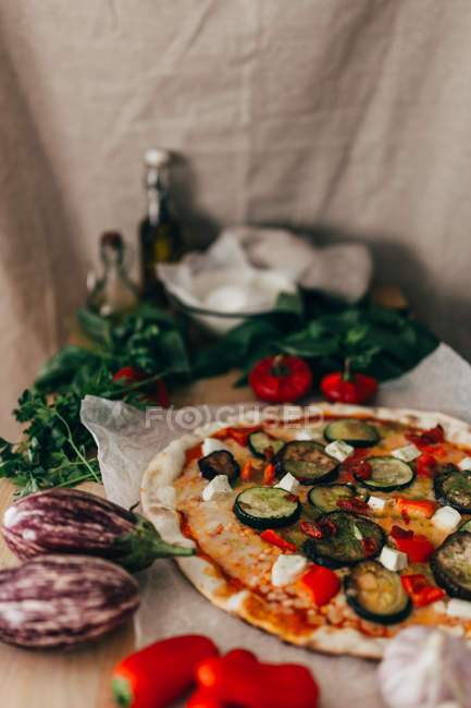 Close up view of ingredients and pizza on table — Stock Photo