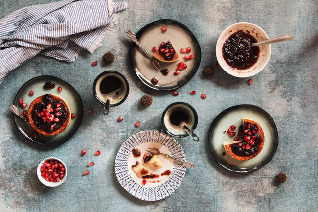 Vista superior de pratos com cheesecake com xícara de café na superfície cinza — Fotografia de Stock